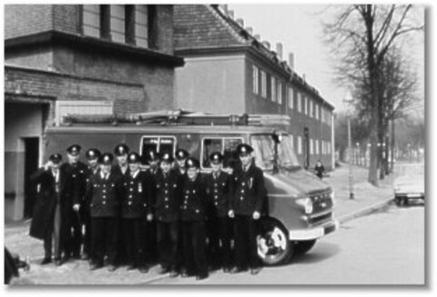 Feuerwehrleute vor Einsatzfahrzeug