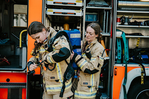 Zwei Feuerwehrfrauen beim Anlegen der Ausrüstung